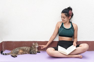 Girl reading a book next to her pet. Love for reading, book day celebration